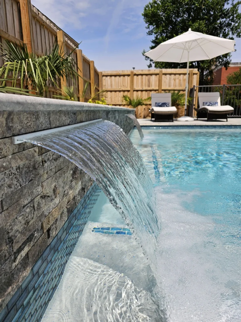 Custom inground pool with surrounding patio and backyard